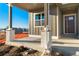 Covered front porch with brick columns and door at 23835 E River Front Dr, Aurora, CO 80019
