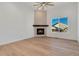 Living room with hardwood floors, corner fireplace, and large window at 23835 E River Front Dr, Aurora, CO 80019
