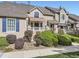 Tan two-story townhome with red door, landscaping, and walkway at 6220 Salvia St, Arvada, CO 80403