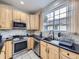 Modern kitchen with stainless steel appliances and light wood cabinets at 6220 Salvia St, Arvada, CO 80403