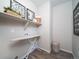 Convenient laundry room with built-in shelving, an ironing board, and ample storage space at 5186 N Quemoy Ct, Aurora, CO 80019