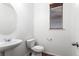 Small half bathroom with pedestal sink and updated toilet at 11735 Helena St, Commerce City, CO 80022