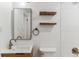 Bathroom with floating vanity, wood shelves, and a large mirror at 4195 S Lipan St, Englewood, CO 80110