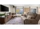 Living room with a brown couch, wooden cabinet, and large window at 1111 Elysian Field Dr # D, Lafayette, CO 80026