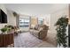 Living room with brown couch, wooden cabinet, and large window at 1111 Elysian Field Dr # D, Lafayette, CO 80026