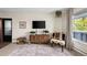 Living room with brown couch, wooden cabinet, and large window at 1111 Elysian Field Dr # D, Lafayette, CO 80026