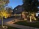 Evening view of a two-story house with landscaping and outdoor lighting at 7899 S Country Club Pkwy, Aurora, CO 80016