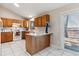 Kitchen with wood cabinets, white appliances, and a breakfast bar at 4227 S Andes Way, Aurora, CO 80013