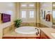 Bathroom with a large soaking tub and window at 9581 Firenze Way, Highlands Ranch, CO 80126