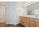 Bathroom with double sinks, light wood cabinets, and a large mirror at 179 N Prairie Falcon Pkwy, Brighton, CO 80601