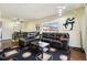 Living room features a leather sectional sofa, coffee table, and hardwood floors at 10211 Ura Ln # 8-207, Thornton, CO 80260