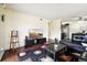 Open concept living room with dark leather sectional and hardwood floors at 10211 Ura Ln # 8-207, Thornton, CO 80260
