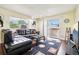 Spacious living room with leather sectional and access to a balcony at 10211 Ura Ln # 8-207, Thornton, CO 80260