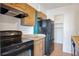 Kitchen with wood cabinets, black appliances, and ample counter space at 4570 E Yale Ave # 702, Denver, CO 80222