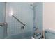 Bathroom with light blue tile, shower and grab bars at 4570 E Yale Ave # 702, Denver, CO 80222