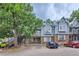 Two-story townhome with blue siding, brick accents, and a spacious parking area at 63 S Sable Blvd # E25, Aurora, CO 80012