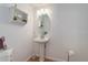 Small bathroom with pedestal sink, mirror, and shelving at 114 E 14Th Ct, Broomfield, CO 80020
