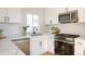 Updated kitchen featuring white shaker cabinets, stainless steel appliances, and a white countertop at 56 S Grant St, Denver, CO 80209