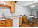 Galley kitchen with wood cabinets and a double sink at 9385 E Center Ave # 1D, Denver, CO 80247