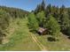 Aerial view of a rustic barn in a green pasture near the woods at 12171 S Critchell Ln, Littleton, CO 80127
