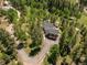 Aerial view of a house nestled in a wooded area with a long driveway at 12171 S Critchell Ln, Littleton, CO 80127
