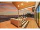 Spacious deck with wooden ceiling, comfortable seating, and beautiful sunset views at 44035 Pony Express Ct, Elizabeth, CO 80107
