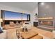 Open living room with a modern fireplace and large windows overlooking deck and sunset at 44035 Pony Express Ct, Elizabeth, CO 80107