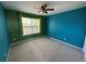 Bright bedroom with teal and green walls, carpet, and a window at 6309 S Newbern Way, Aurora, CO 80016