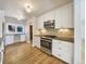 Updated kitchen with white cabinets, granite counters, and hardwood floors at 7264 Siena Way # C, Boulder, CO 80301