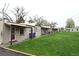 Tan colored multi-unit building with covered porches and a grassy yard at 2660 Utica St, Denver, CO 80212