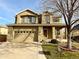 Two-story house with tan siding, a large garage, and a landscaped front yard at 12578 Dexter Way, Thornton, CO 80241