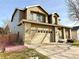 Two-story house with tan exterior, a three-car garage, and a well-maintained lawn at 12578 Dexter Way, Thornton, CO 80241