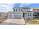 Two-story house with gray siding, three-car garage, and landscaped yard at 2053 S Cathay Way, Aurora, CO 80013