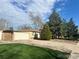 Ranch-style home with attached garage and mature landscaping at 1235 S Benton St, Lakewood, CO 80232