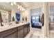 Double vanity bathroom with a view into the bedroom and walk-in shower at 6621 N Ceylon St, Denver, CO 80249