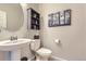 Small bathroom with pedestal sink, toilet and decorative wall art at 6621 N Ceylon St, Denver, CO 80249