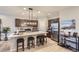 Modern kitchen with dark cabinets, a large island, and stainless steel appliances at 6621 N Ceylon St, Denver, CO 80249