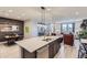 Open concept kitchen features an island, stainless steel appliances, and a view into the living room at 6621 N Ceylon St, Denver, CO 80249