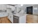 Modern kitchen with white cabinets, island, and fireplace at 3452 N Gold Bug Ct, Aurora, CO 80019
