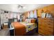 Bedroom with double bed, wooden dresser, and orange bedding at 907 Elm Ct, Fort Lupton, CO 80621