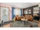 Living room with brown couches, coffee table, and view into adjacent bedroom at 907 Elm Ct, Fort Lupton, CO 80621