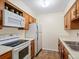 Neat kitchen featuring white appliances and wood cabinets at 3600 S Pierce St # 5-204, Denver, CO 80235