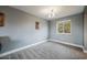 Spacious bedroom with gray walls, plush carpet, and a large window at 7313 S Teller Ct, Littleton, CO 80128