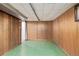 Finished basement room with wood paneling and green flooring at 3112 Salem St, Aurora, CO 80011