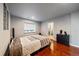 Bright bedroom with wood floors, plush bedding, and ensuite bathroom access at 5562 Rim View Pl, Parker, CO 80134