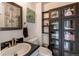 Bathroom with dark vanity and linen cabinet with glass doors at 2790 S Wheeling Way, Aurora, CO 80014