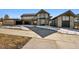 Stunning modern home with stone and wood accents, showcasing a large driveway and attached garage at 7916 Forest Keep Cir, Parker, CO 80134