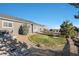 Landscaped backyard with grassy area and rock features at 3153 Eagle Claw Pl, Castle Rock, CO 80108