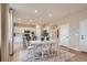 Kitchen and dining area with white cabinets, hardwood floors, and a farmhouse table at 1369 Bloom St, Brighton, CO 80601