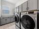 Modern laundry room with gray cabinets, granite countertops, and high-efficiency washer and dryer at 18472 W 95Th Pl, Arvada, CO 80007